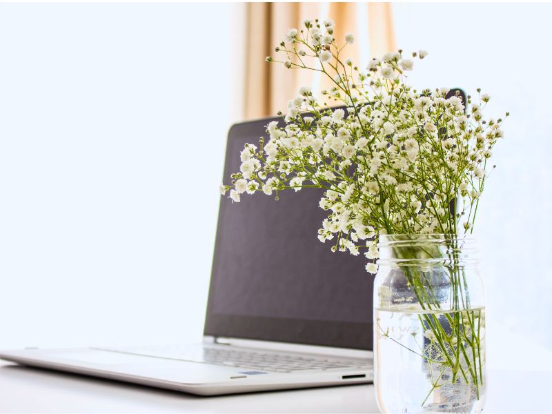 Laptop with some flowers next to it