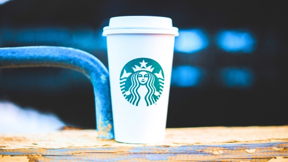 A photo of a cup of Starbucks coffee sitting on a piece of wood
